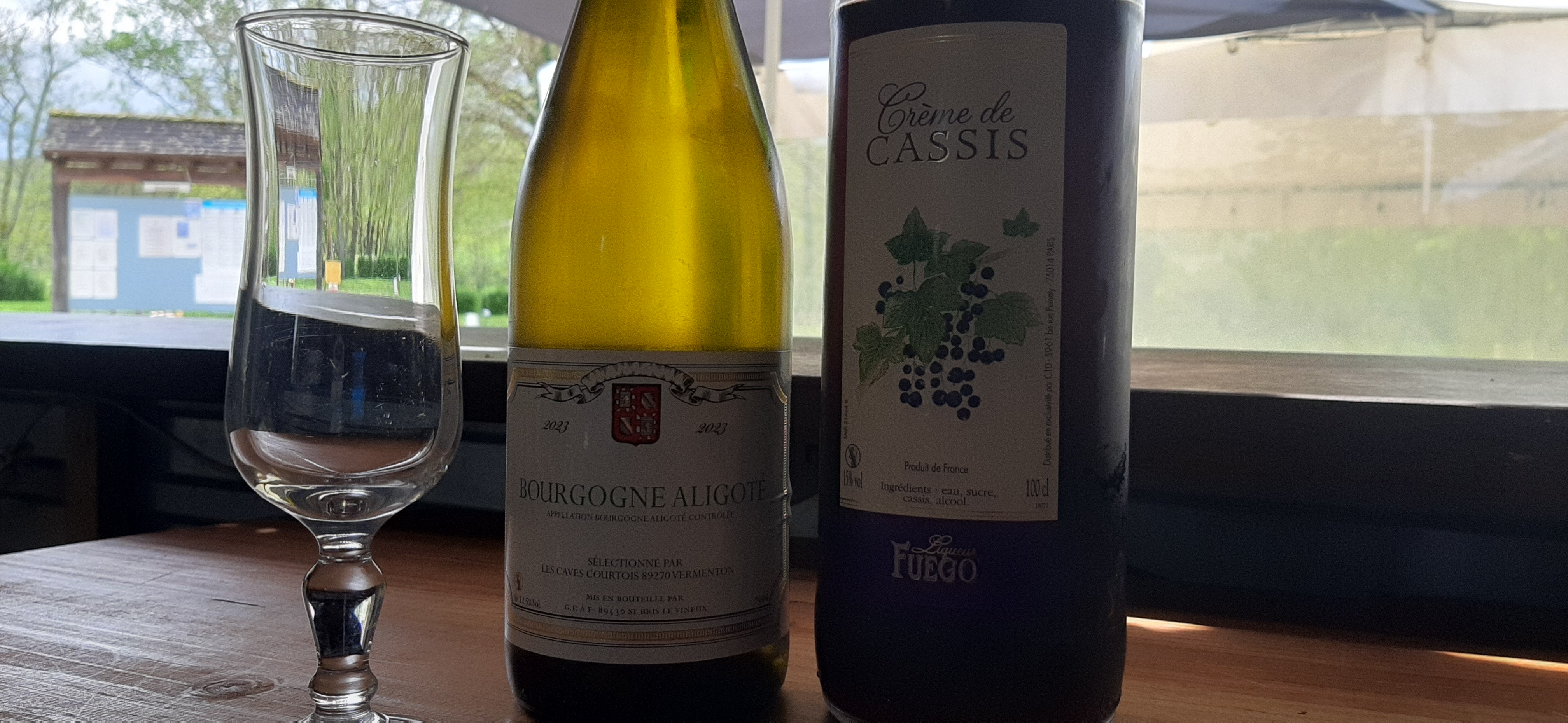 Photo d'une de vin blanc Bourgogne Aligoté, une bouteille de crème de Cassis et une coupe de champagne